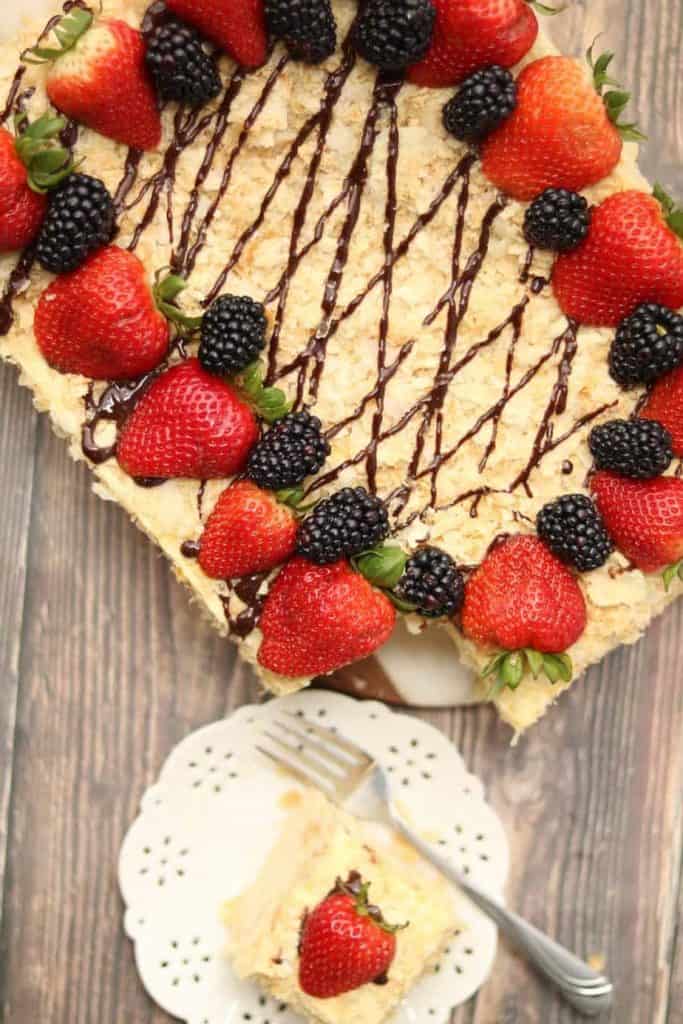Russian Napoleon puff pastry cake with chocolate drizzle and topped with berries