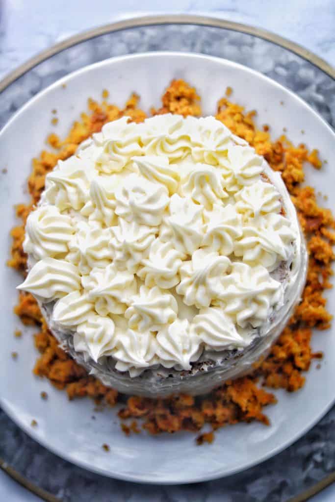 A fluffy carrot cake covered with delicate swirls of cream cheese frosting 