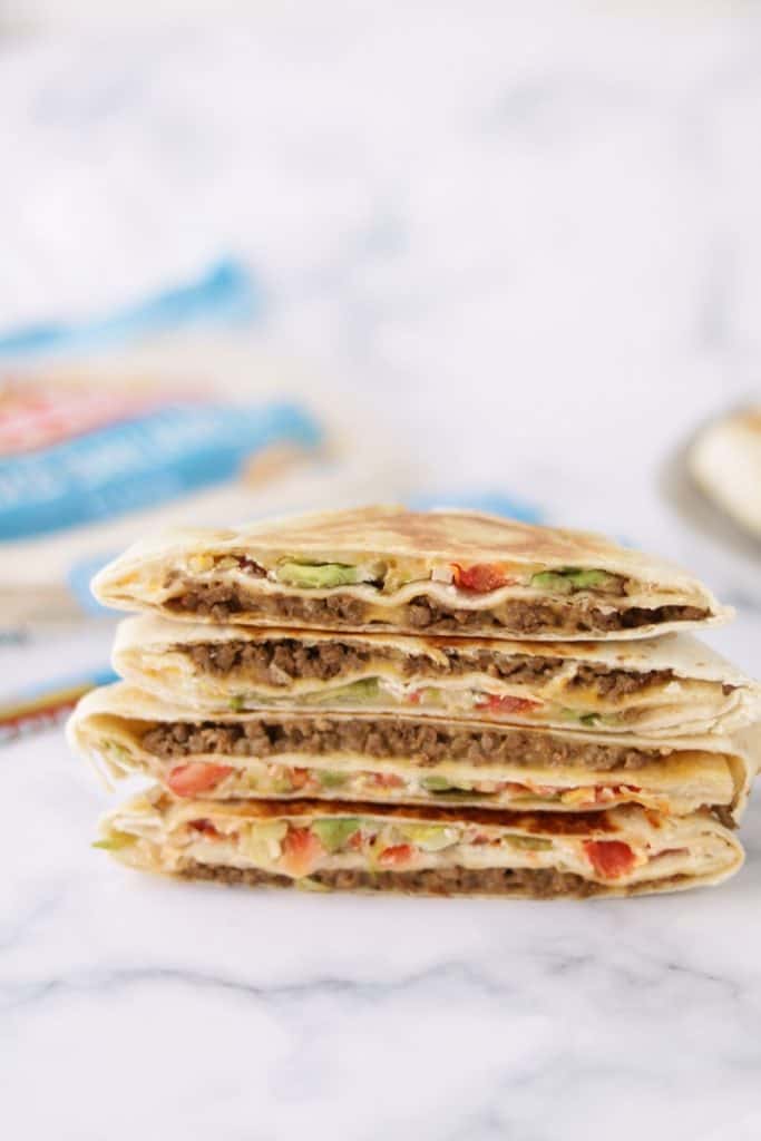 This keto crunchwrap supreme is filled with ground beef, nacho cheese, tostada, sour cream, avocado, tomato, lettuce, jalapeno, and cheese