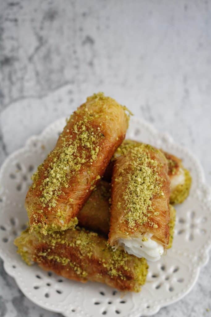 golden crunchy Kunafa Rolls drizzled with sugar syrup and garnished with crushed pistachios