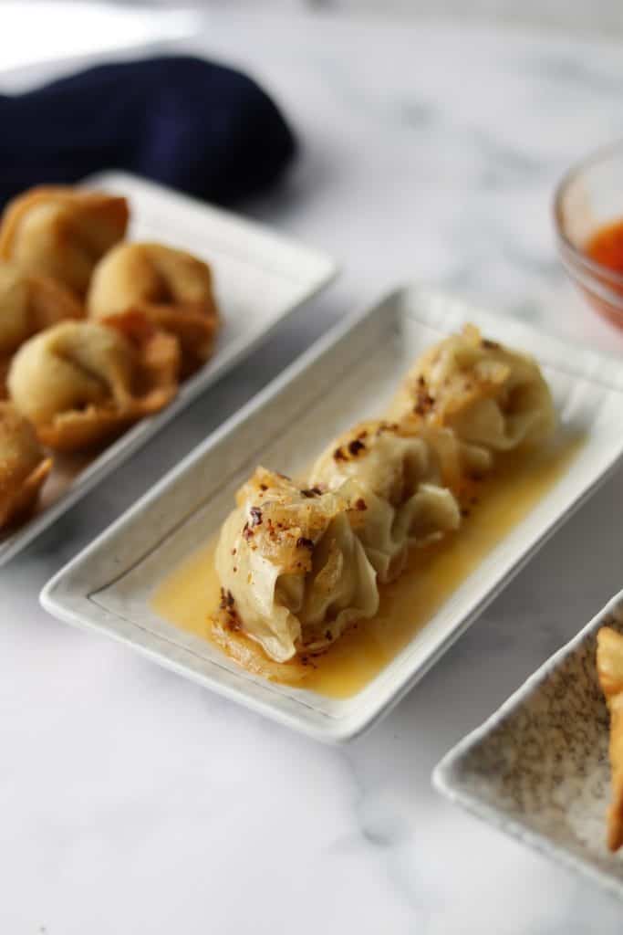 delectable fried chicken wontons having crunchy texture and served with hot chili sauce 