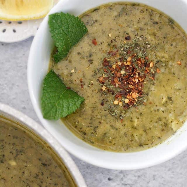 A Warm Bowl Of Healthy Red Lentil Soup with Mint Garnished with Some Chili Flakes and Dried Mint. 