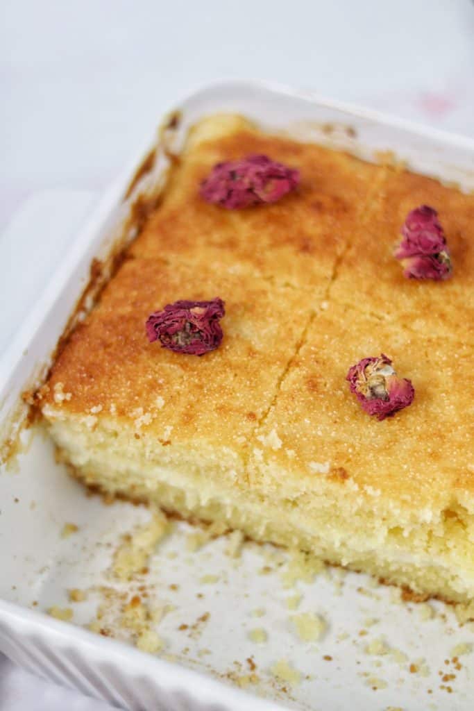 easy and delicious basbousa with ashta cream, drizzled with attar syrup, and garnished with rosebuds
