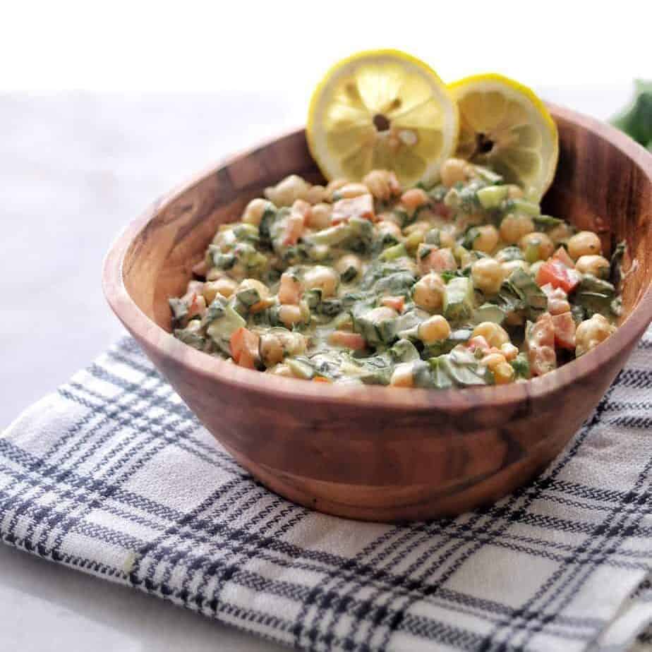 An unique Vegan Tahini Chickpea Salad.   Chickpeas are mixed with some greens, a tomato and Tahini dressing. You will a juicy delicious bowl of salad at the end. 