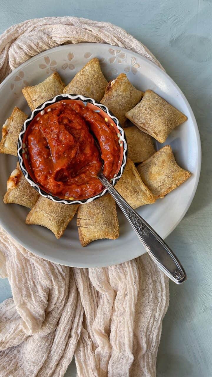 golden pizza rolls in the air fryer, with a crunchy outside texture and cheesy inside,  served with  marinara sauce
