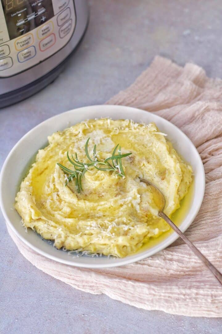 creamy skin on yukon gold mashed potatoes made using an instant pot and topped with olive oil, parmesan cheese, and rosemary 