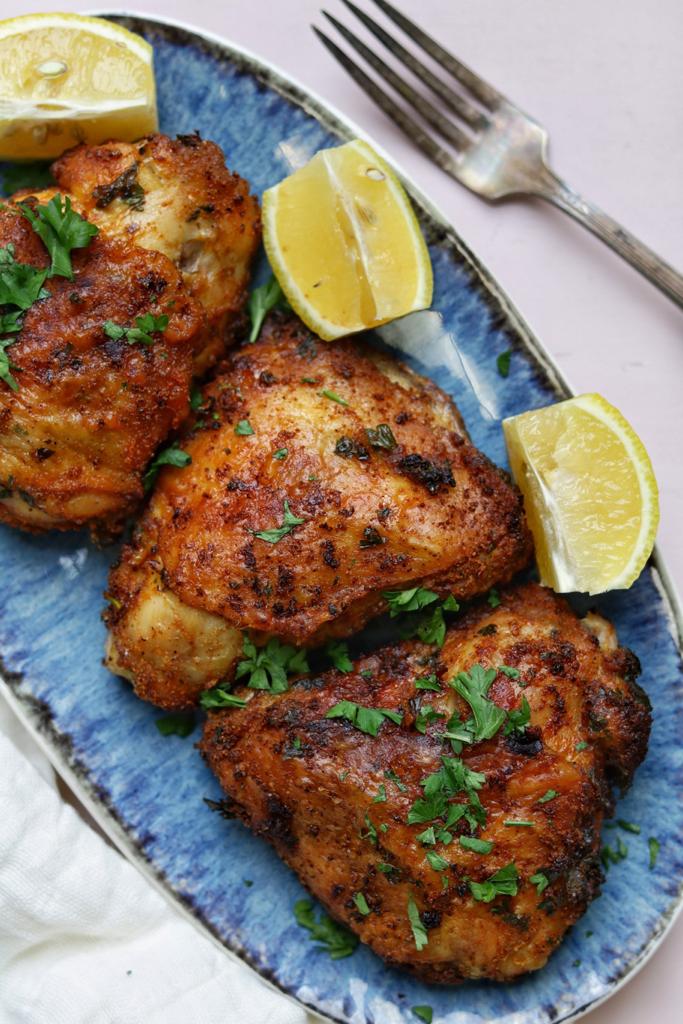 Tender and juicy air fried chicken thighs served with lemon cutlets and topped with fresh parsley finely chopped. The golden crispy skin on looks so yummy!