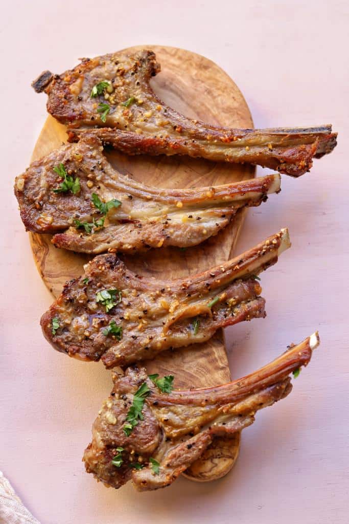 Marinated simply in unseasoned meat tenderizer powder, garlic, and olive oil and air fried to perfection, these lamb chops are so quick easy to make.