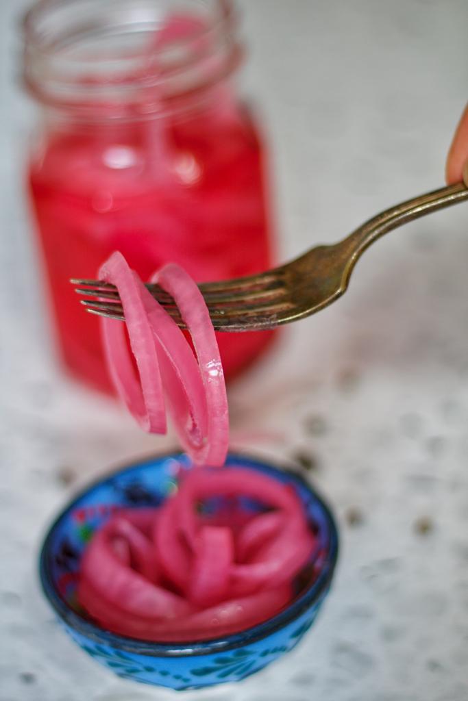 Vibrant pink onions pickled in vinegar and salt brine is the perfect condiment for your sandwiches.
