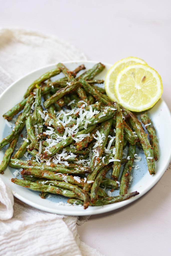 Fresh green beans with crispy texture topped with some grated parmesan cheese and served lemon cutlets