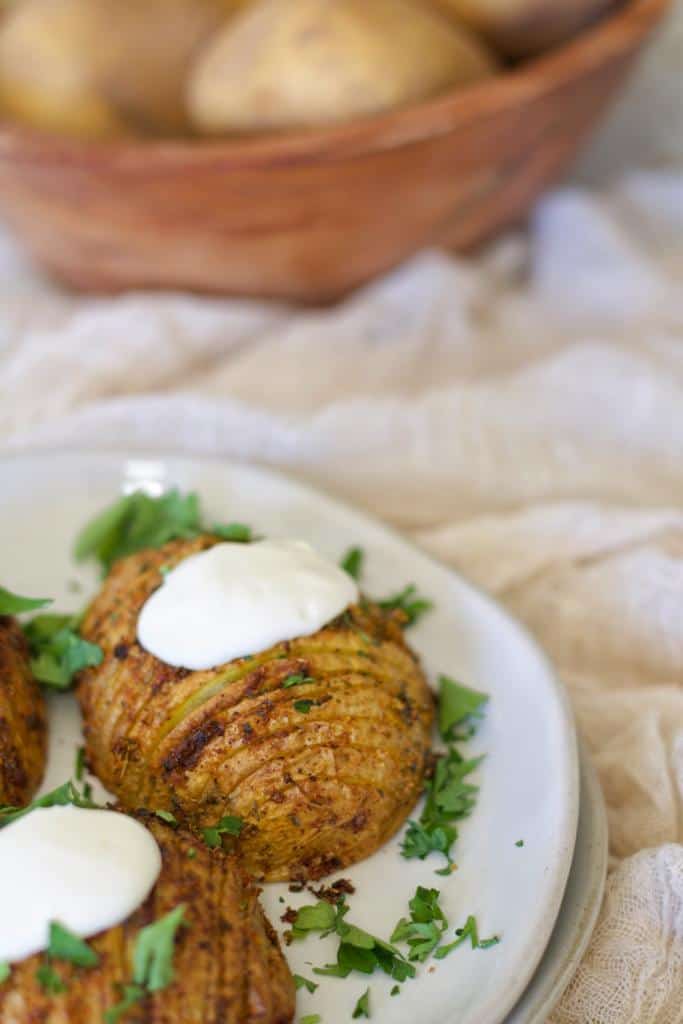Crispy cheesy mini Hasselback potatoes seasoned with a flavorful mix of spices and Vegeta seasoning. Before serving, top these Hasselback potatoes with sour cream and garnish them with finely chopped fresh parsley.