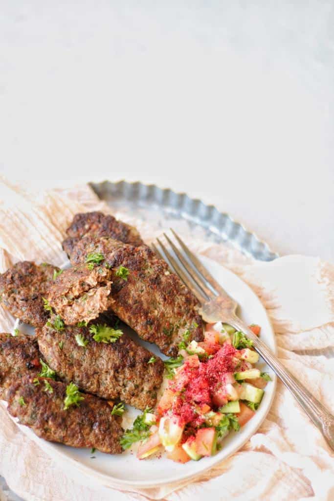 Beef kafta kabob made served with lebanese fattoush salad and garnished with finely chopped fresh parsley. They are so yummy!