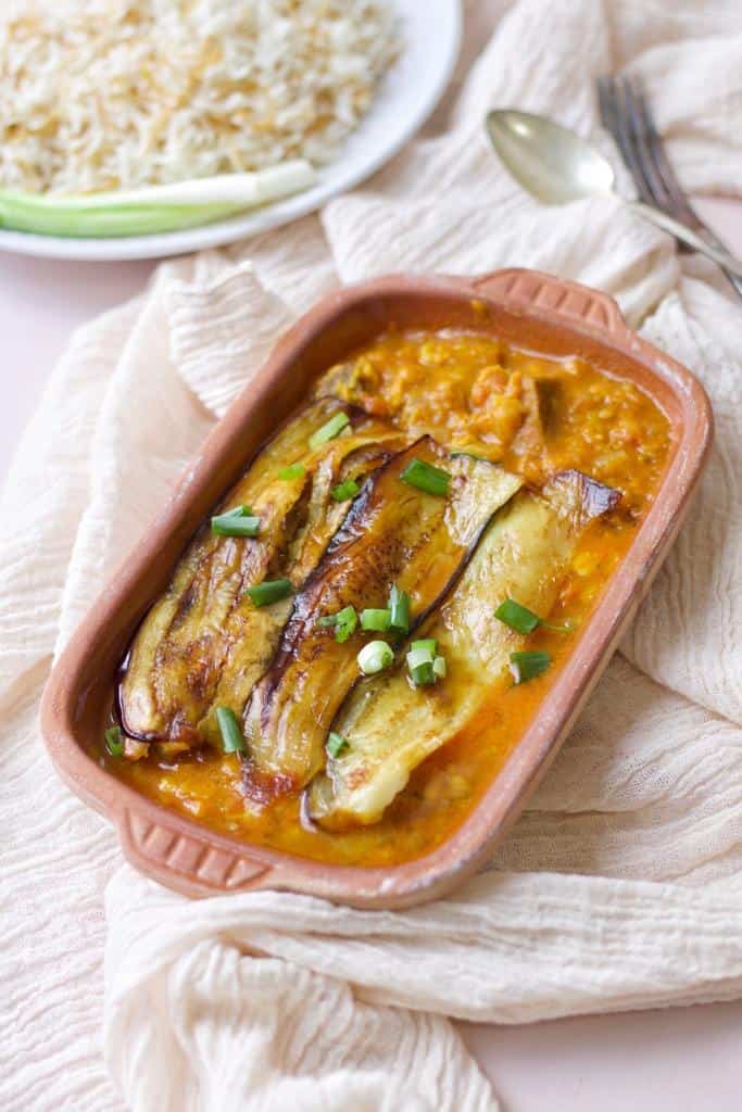 A hearty dish of Persian eggplant stew made with meltingly soft aubergine in a thick and tangy tomato-based sauce, with tender meat pieces served with vermicelli rice