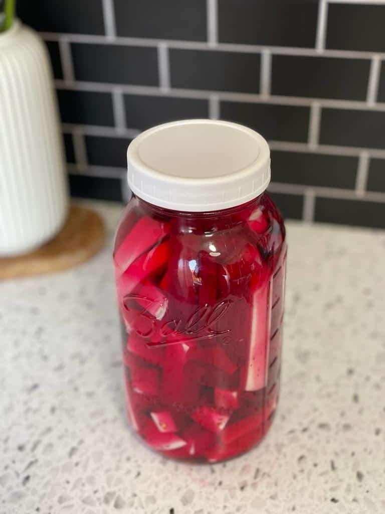 a jar of ½-inch thickness peeled and cut beets and turnips submerged in a liquid of purified water, white vinegar, and Kosher salt.