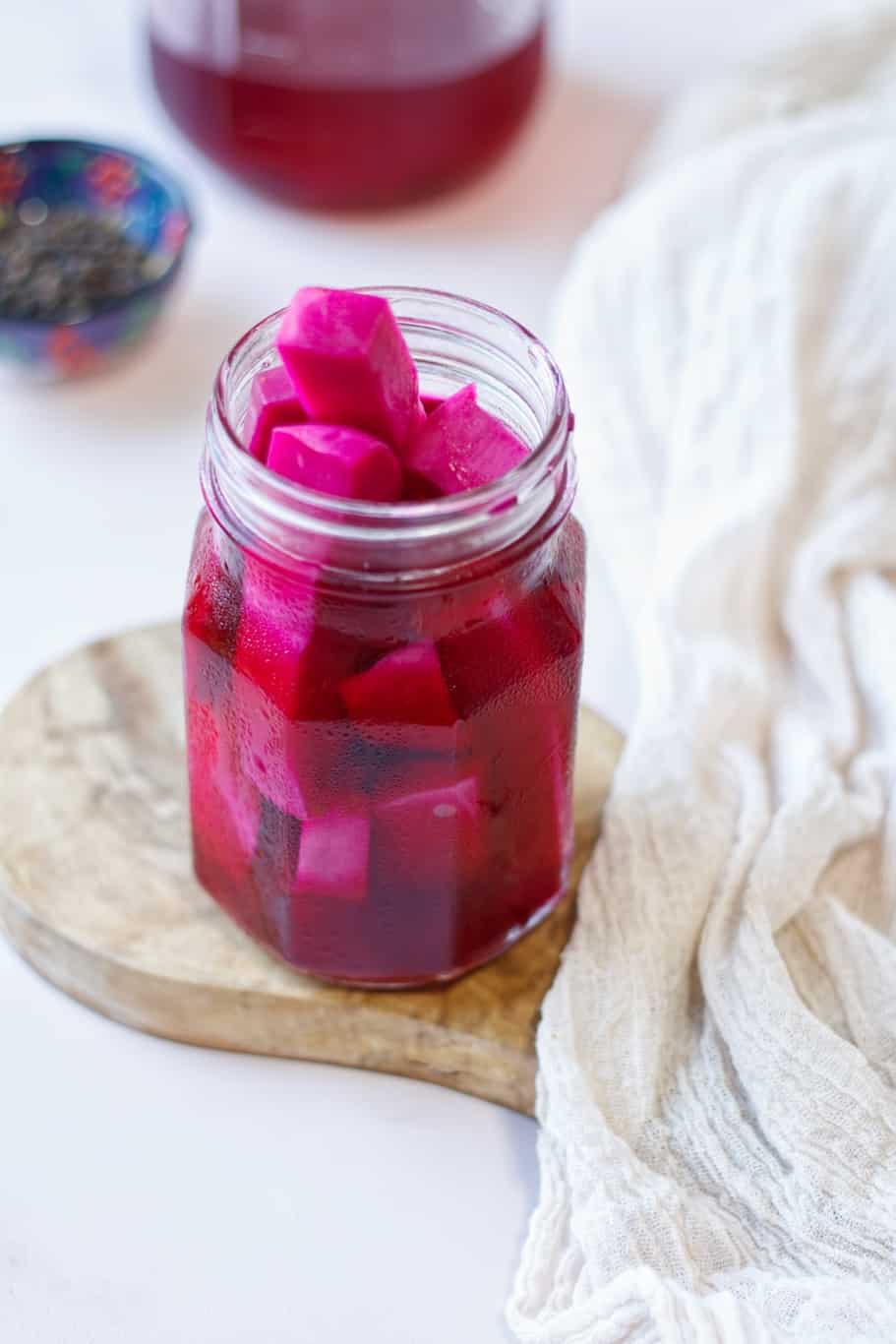 A jar of refrigerator pink pickled turnips which are cut into ½-inch thickness, about the size of French fries.