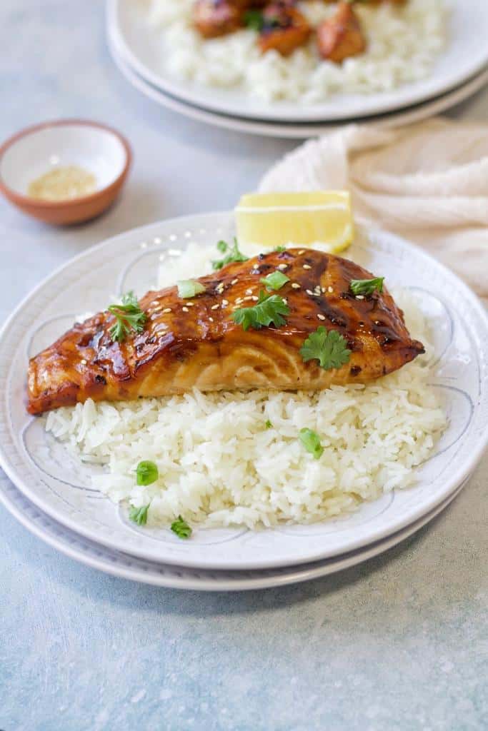 caramelized air fried teriyaki salmon fillets cooked to perfection then garnished them with sesame seeds and finely chopped fresh parsley, and serve them with hot rice side dish and lemon cutlets
