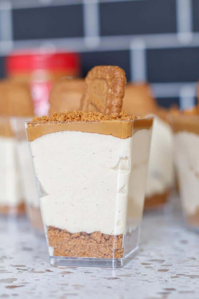 Mini cheesecake cups made with a buttery Biscoff biscuit base, a creamy Biscoff (cookie butter) cheesecake filling, and a Lotus Biscoff biscuits on top. 
