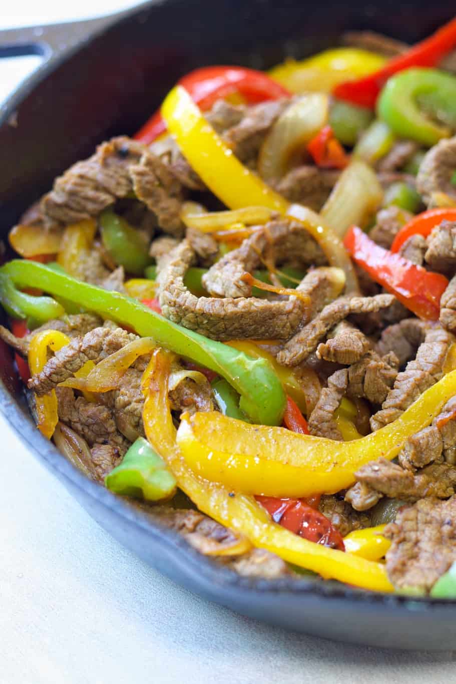 keto-friendly fajitas skillet made up of skirt steak, onions, green, red, and yellow bell peppers