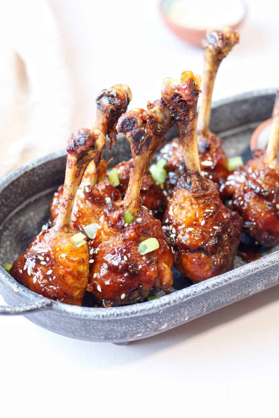 honey soy chicken drumsticks air fryer topped with sesame seeds and chopped green onions