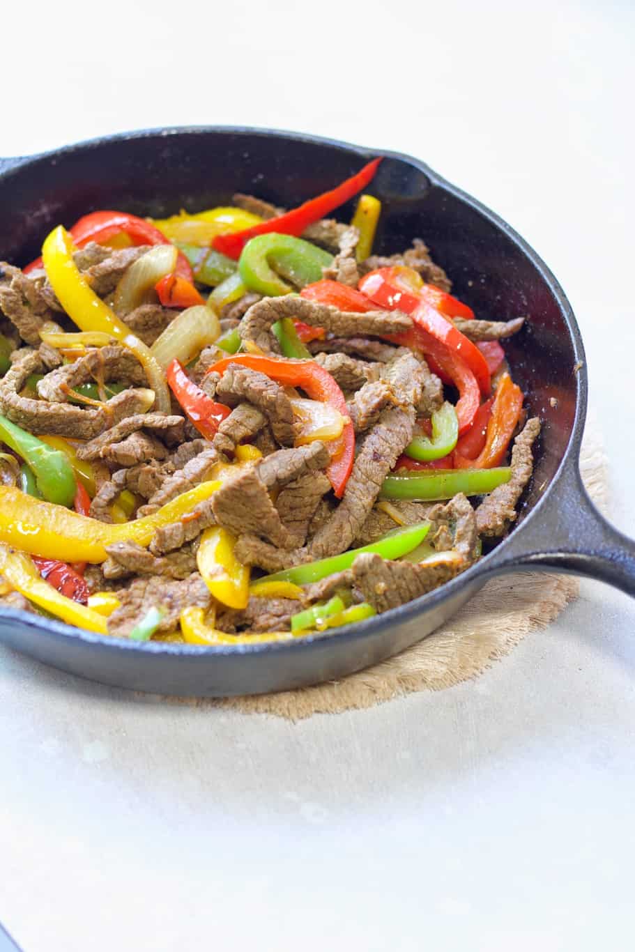 A hearty Keto Steak Fajita Skillet made up of skirt steak, onions, green, red, and yellow bell peppers