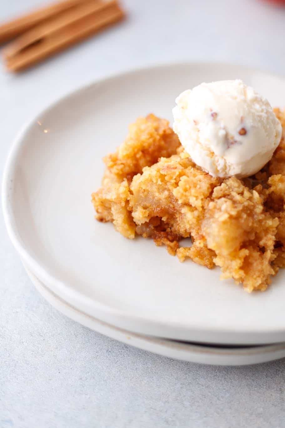 a piece of apple dump cake topped with a scoop of ice cream makes the perfect dessert