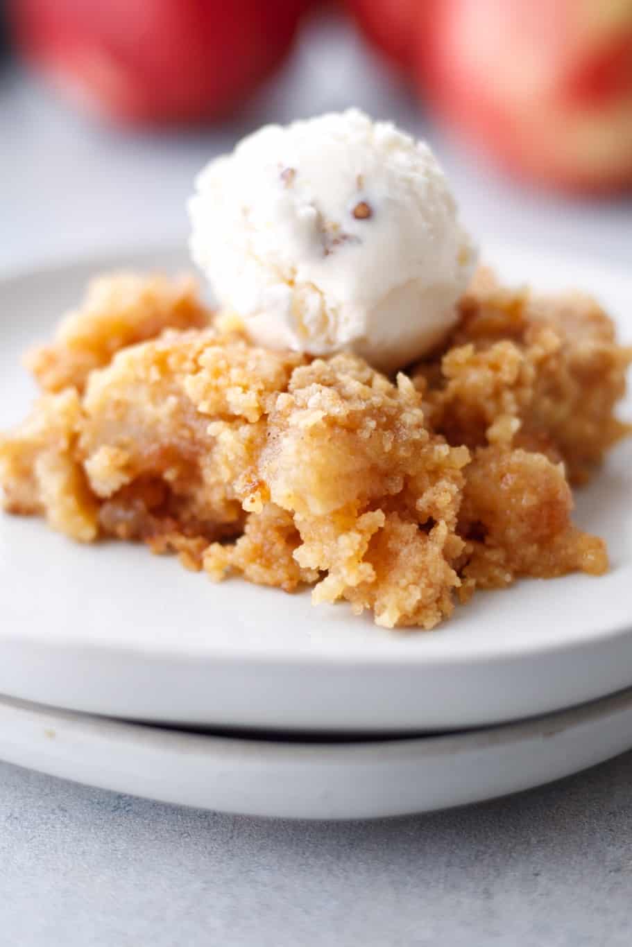 apple cobbler dessert topped with a scoop of vanilla icecream