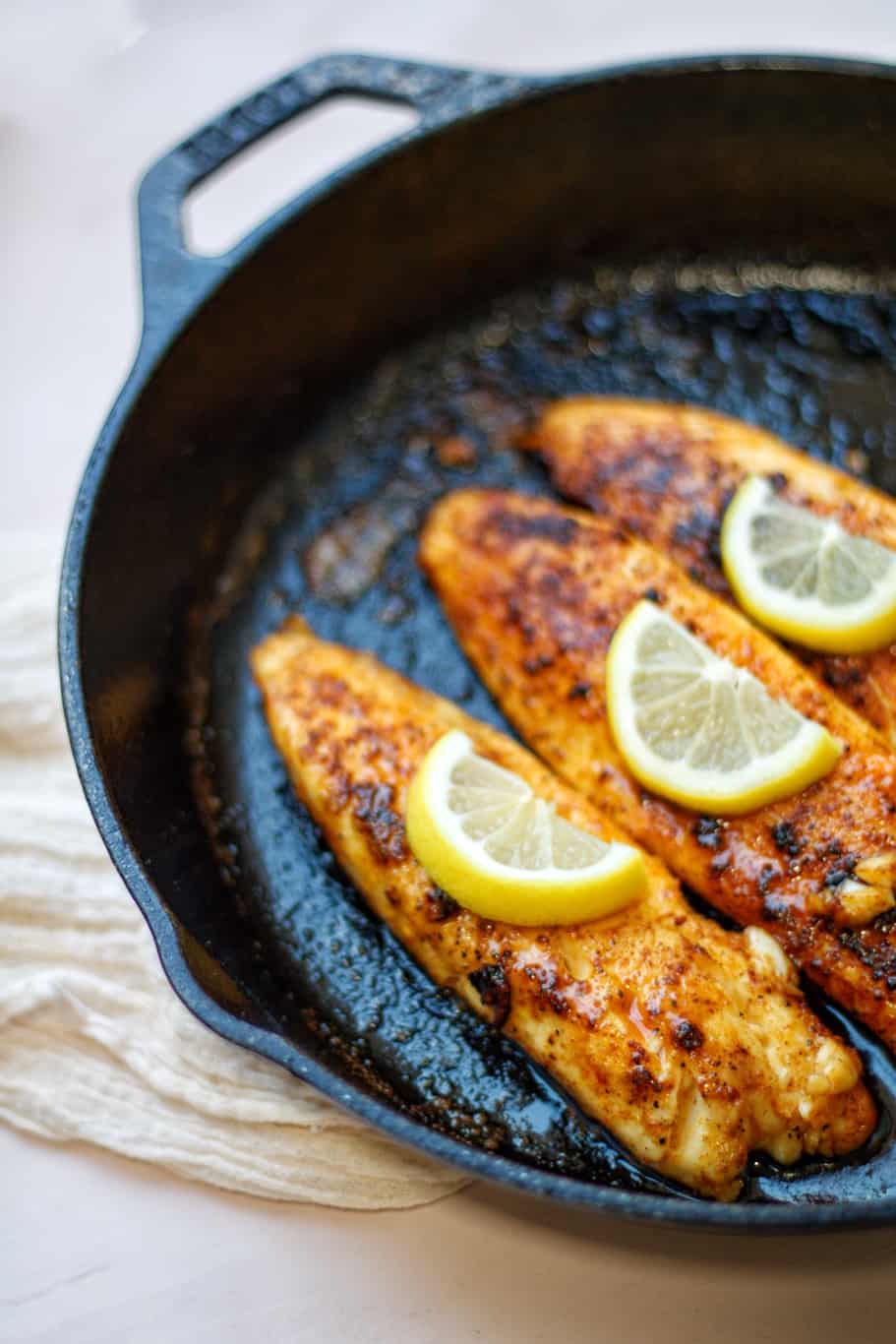 delicious pan seared tilapia fillers cooked in a cast iron skillet