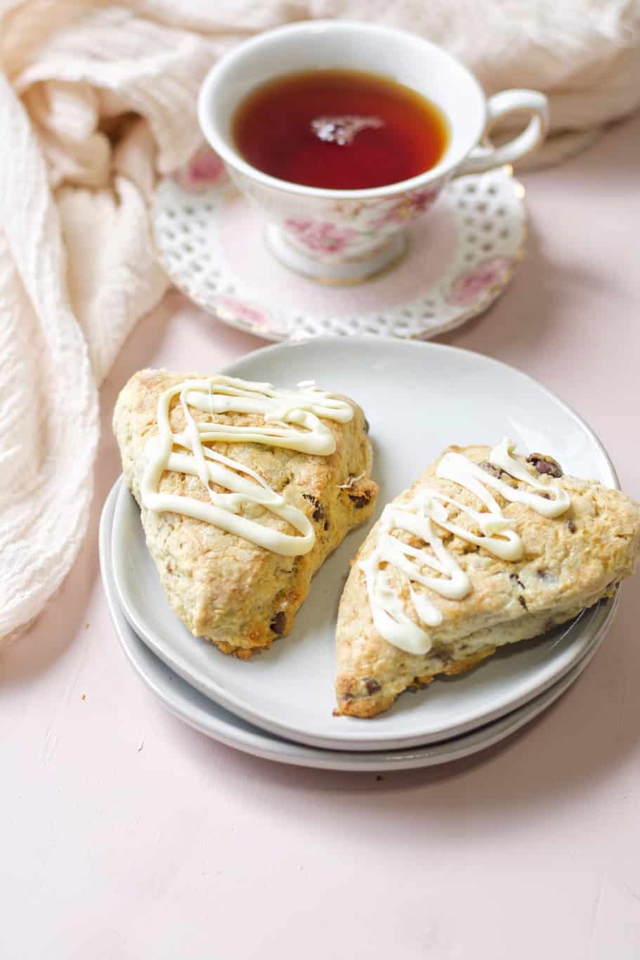 flaky dessert drizzled with melted white chocolate filled with chocolate chips and served with a cup of tea
