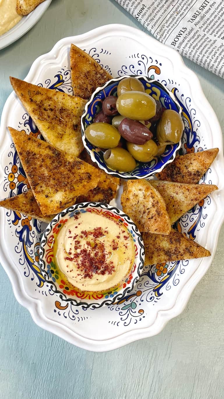 crispy pita chips made up of pita bread pockets, seasoned to perfection, air fried until golden brown, and served with olives and hummus