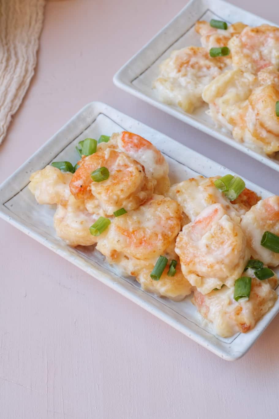 Creamy Coconut Shrimp served with a decadent white sauce and garnished with green onion

