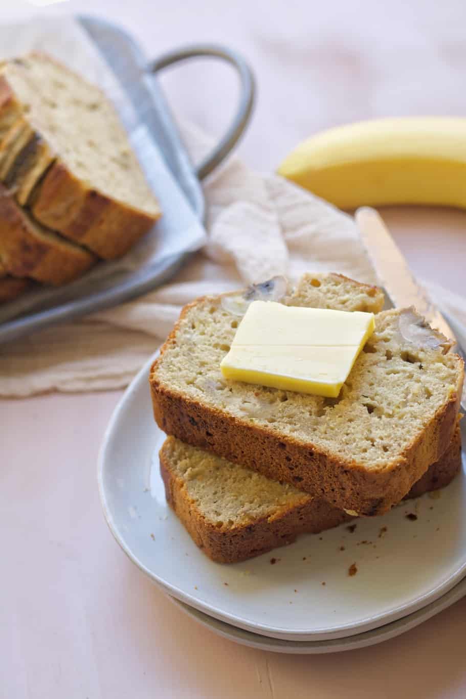fluffy and moist banana bread slices topped with a piece of butter