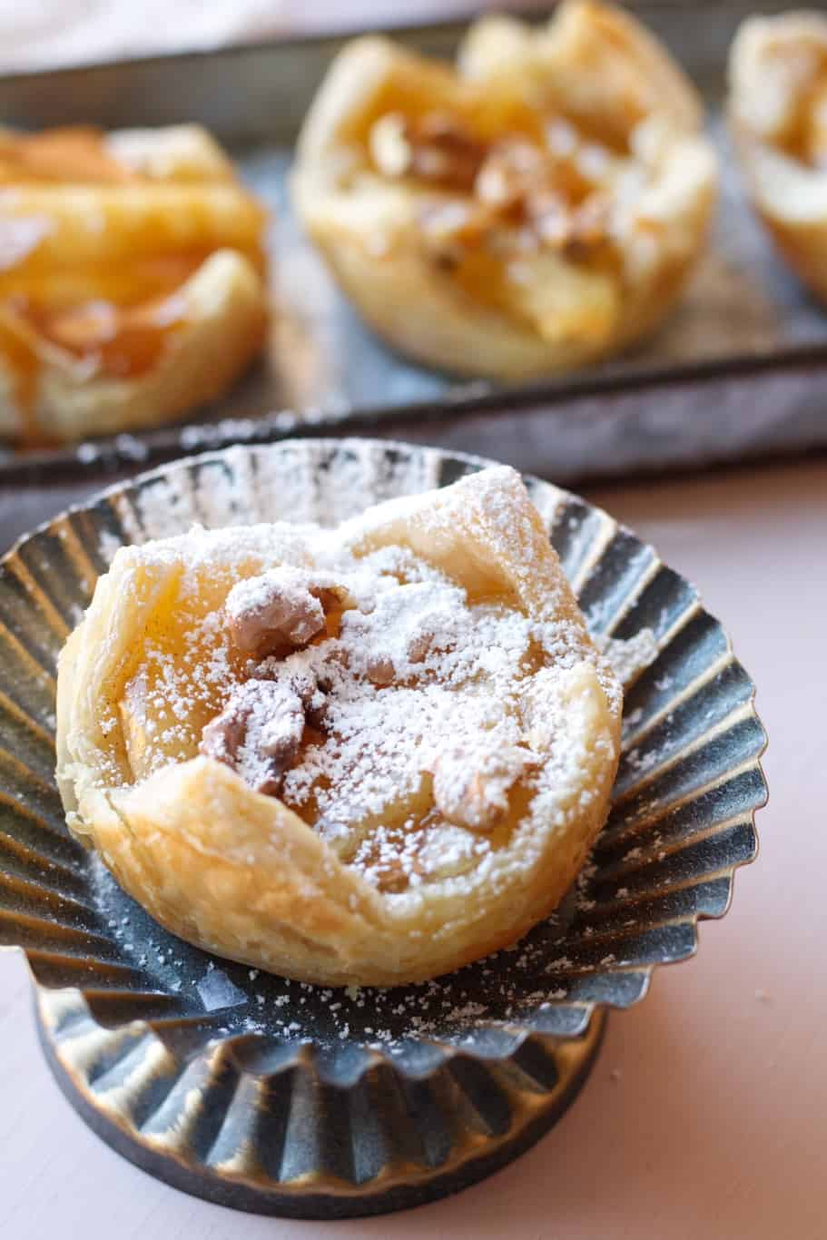 an apple pie bites with puff pastry sprinkled with powdered white sugar before serving