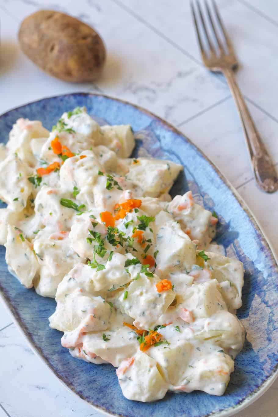 refreshing chilled potato salad with finely chopped fresh parsley and finely chopped carrots on the top