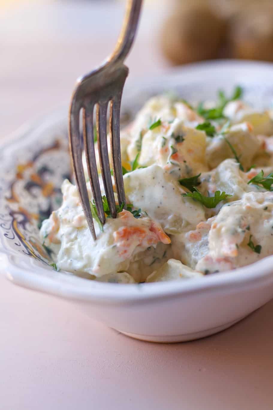 creamy Juan Pollo Potato salad sprinkled with finely chopped fresh parsley