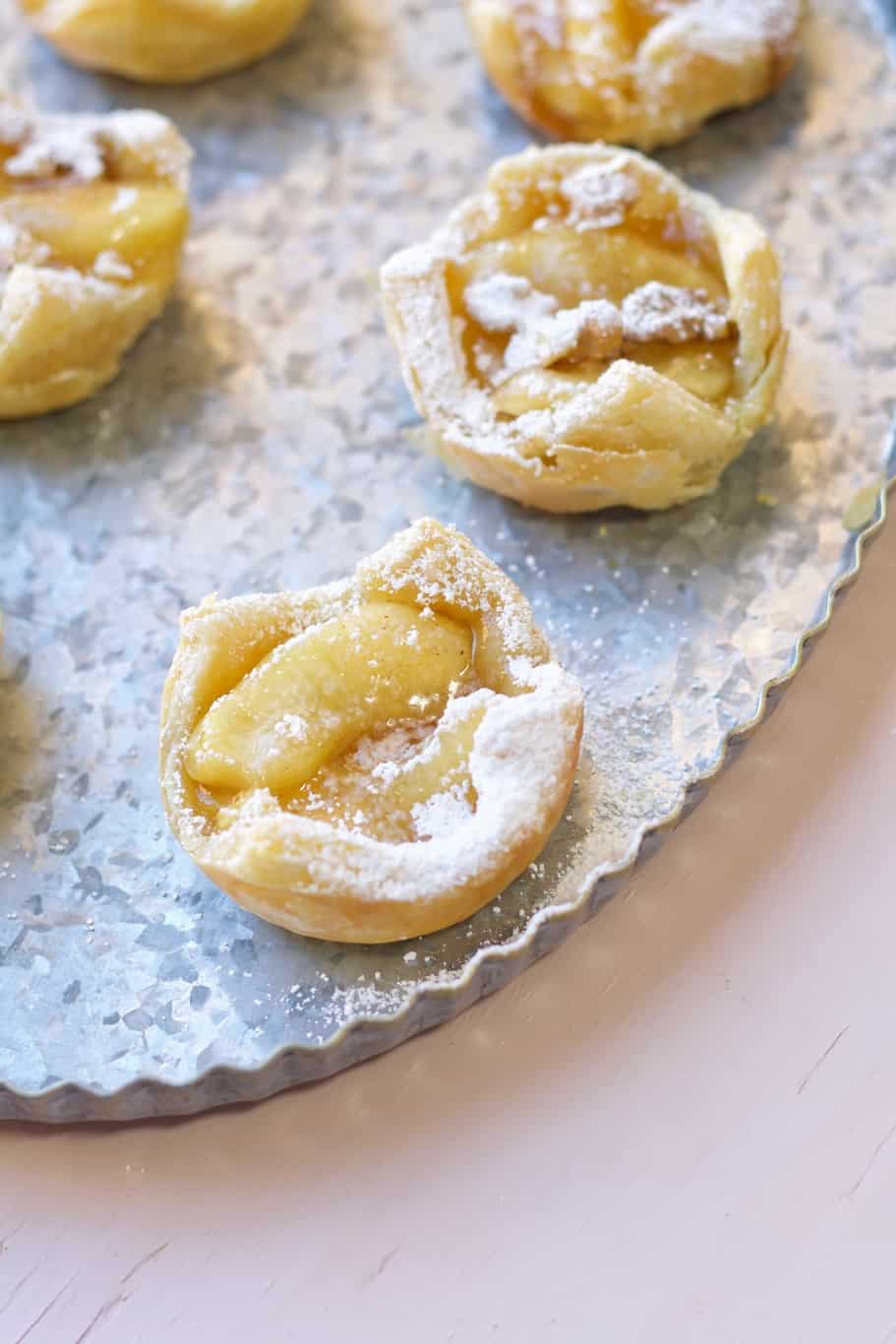 serve these baked apple tarts in muffin pan with puff pastry warm with  powdered white sugar on the top