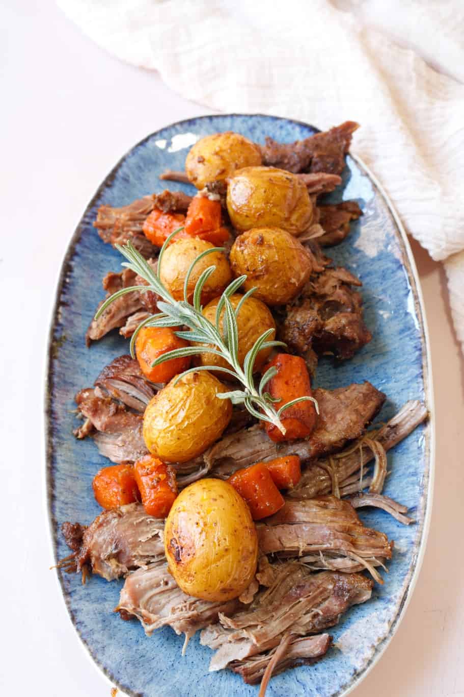 Succulent Slow Roasted Boneless Leg of Lamb with colorful vegetables and fresh rosemary