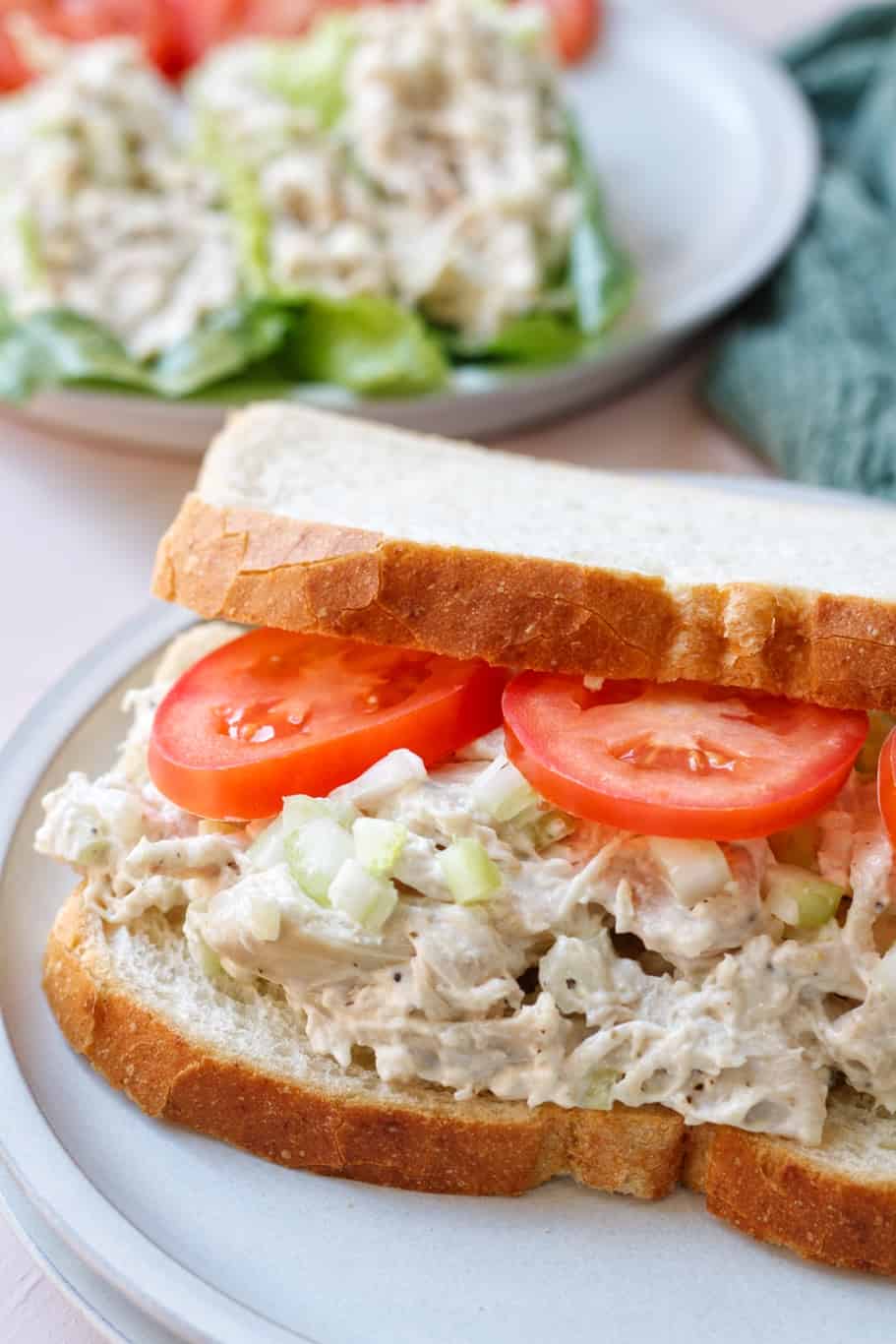 creamy 5 ingredient chicken salad served as sandwich on sourdough bread and fresh tomatoes