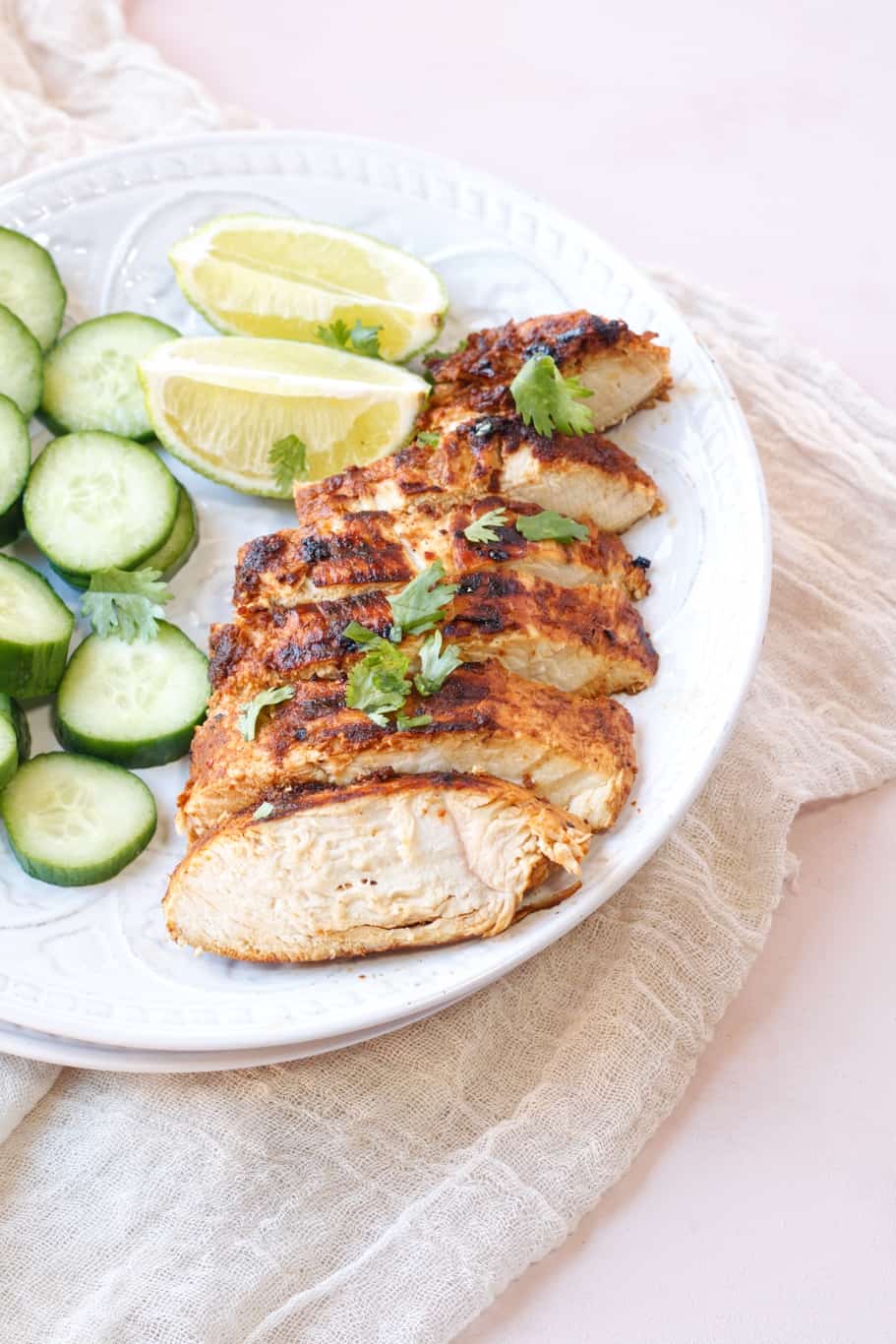 delicious pollo asado chicken breast cut into pieces and served with cucumber and lemon wedges