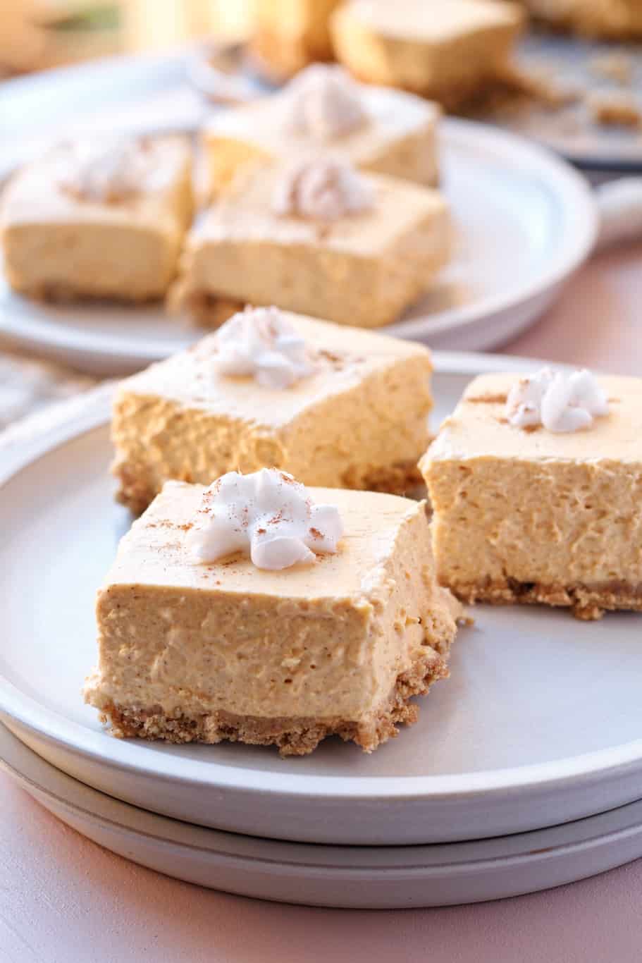 Serve chilled no-bake pumpkin bars with whipped cream before serving and a sprinkle of cinnamon on the top.