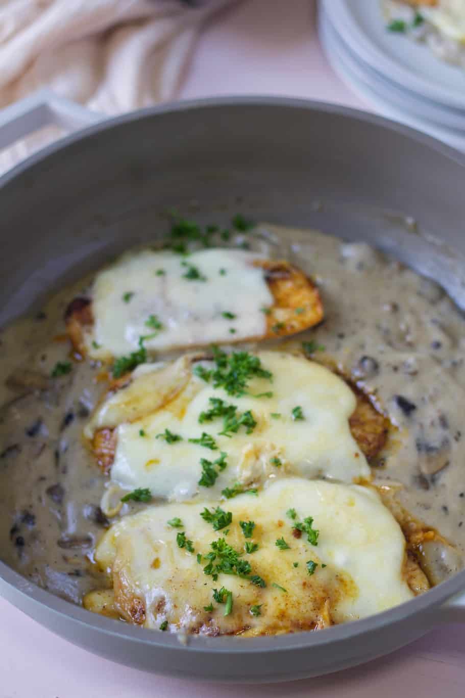 Chicken breasts topped with cheese and served with a creamy mushroom sauce
