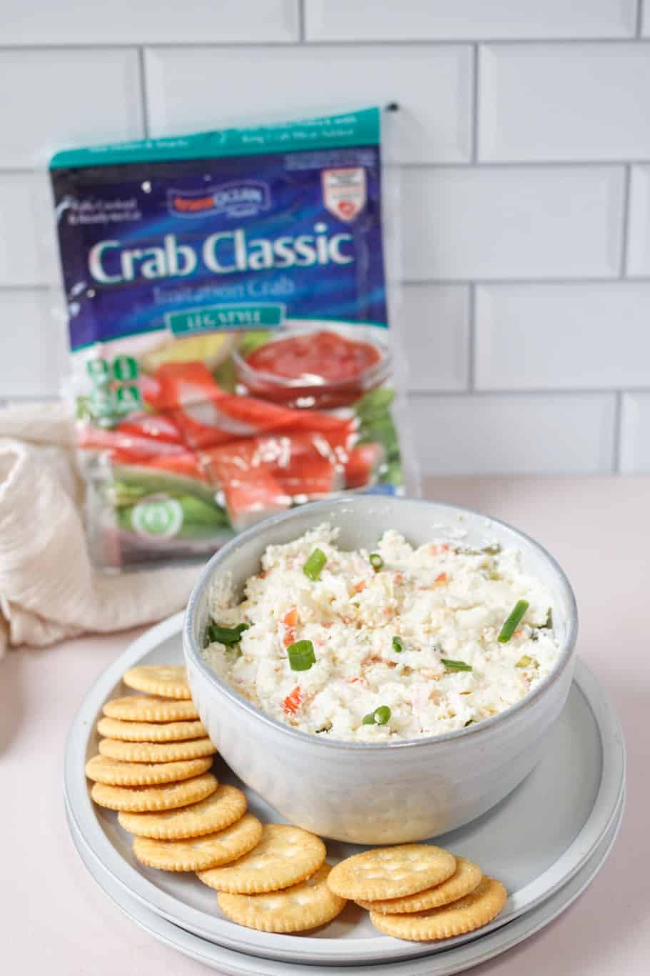 A delicious bowl of cream cheese crab dip served with some crackers