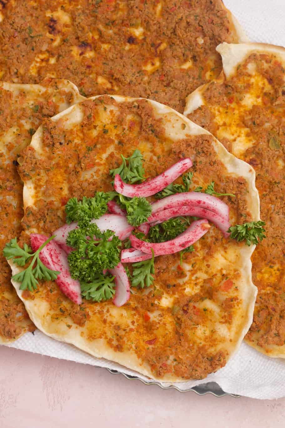 spicy lahmajun wraps garnished with onions and fresh herbs