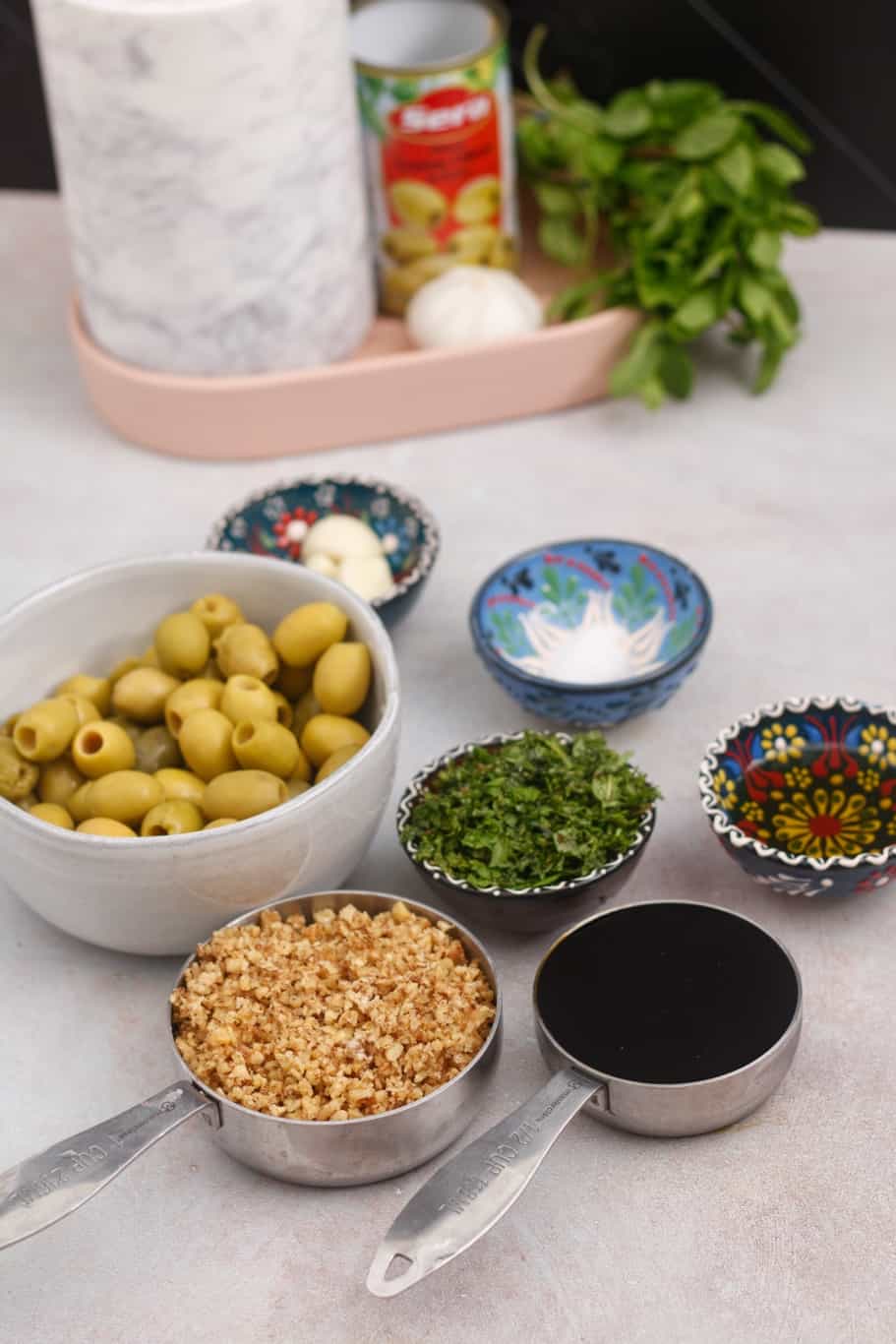these are the ingredients to make Persian marinated olives recipe: green olives, olive oil, chopped walnuts, pomegranate molasses, garlic, and chopped fresh mint.