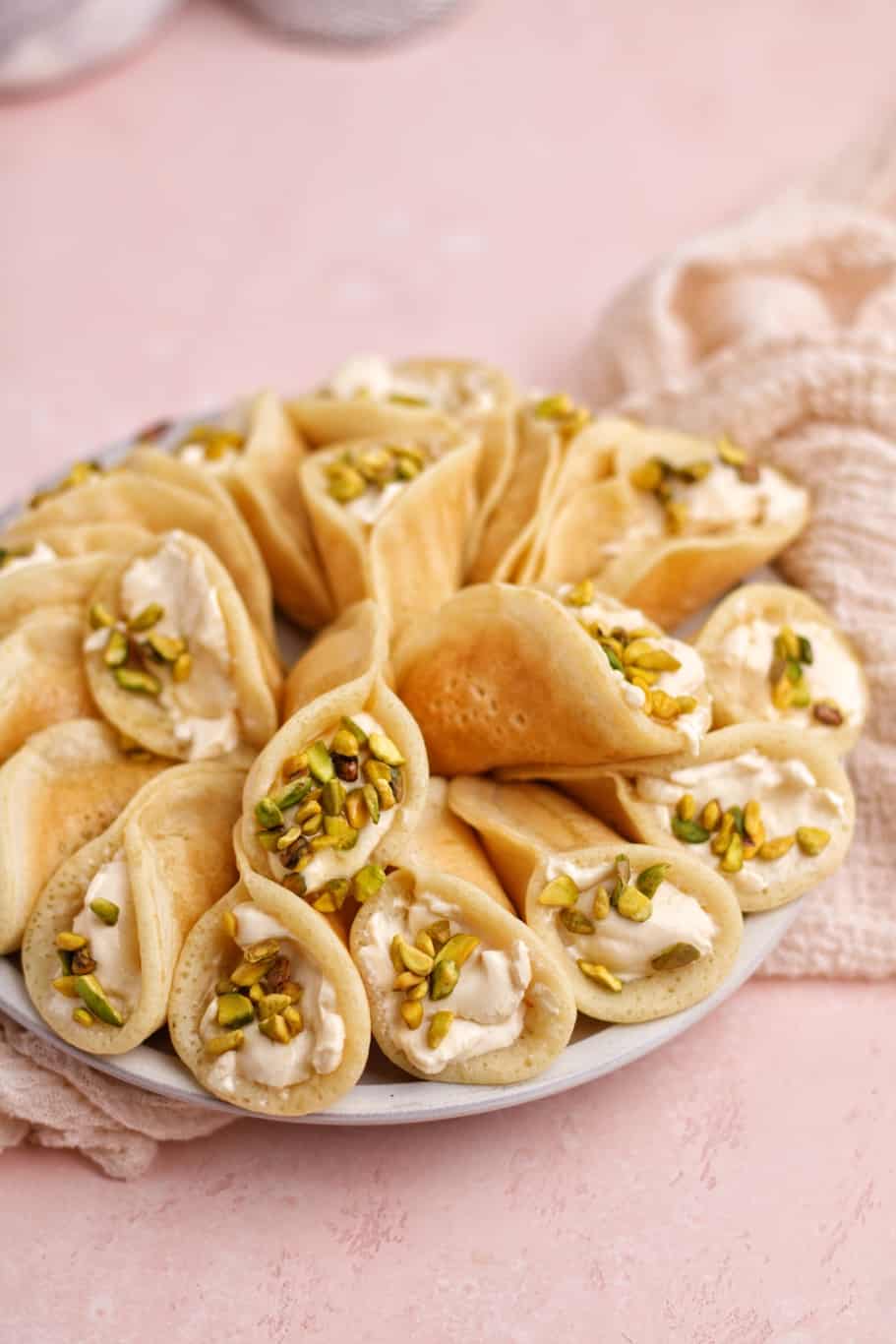 delicious qatayef asafiri filled with ashta cream and topped with crushed pistachios