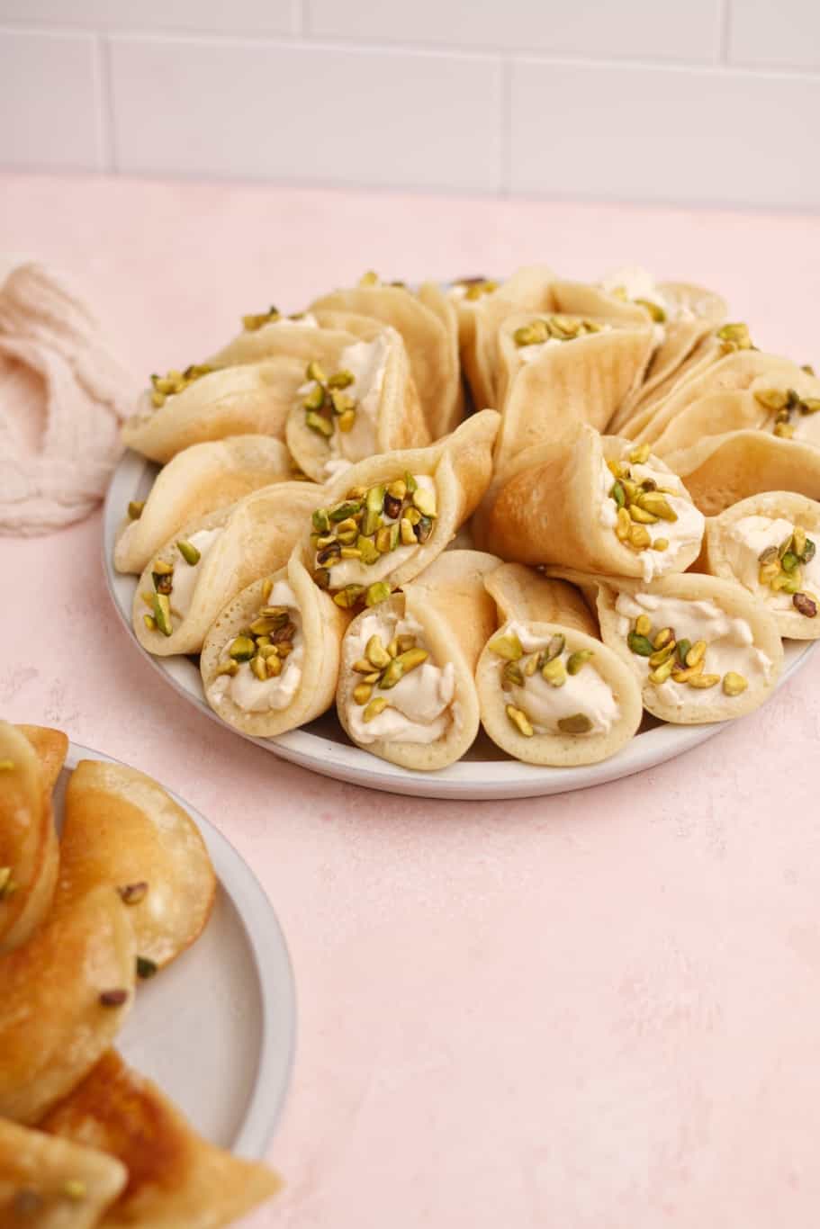 small semolina-yeast pancakes filled with ashta cream and topped with crushed pistachios