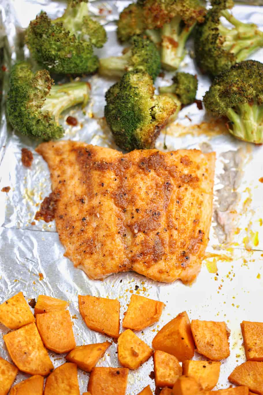 salmon filet with sweet potatoes and broccoli on the baking tray