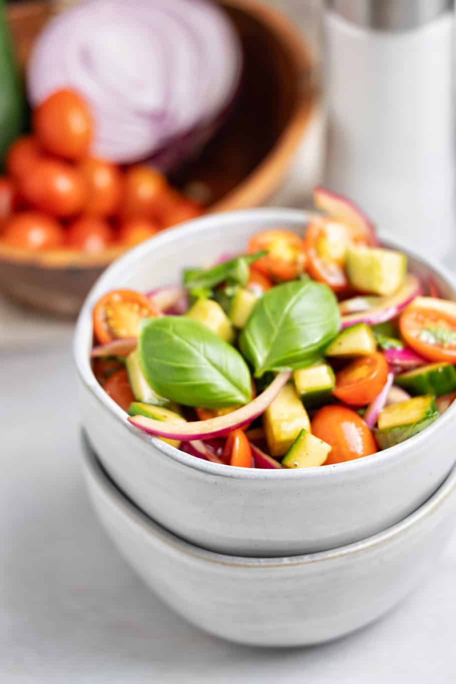 a small bowl of simple Panera basil tomato cucumber salad is loaded with fresh ingredients and bursting with flavor