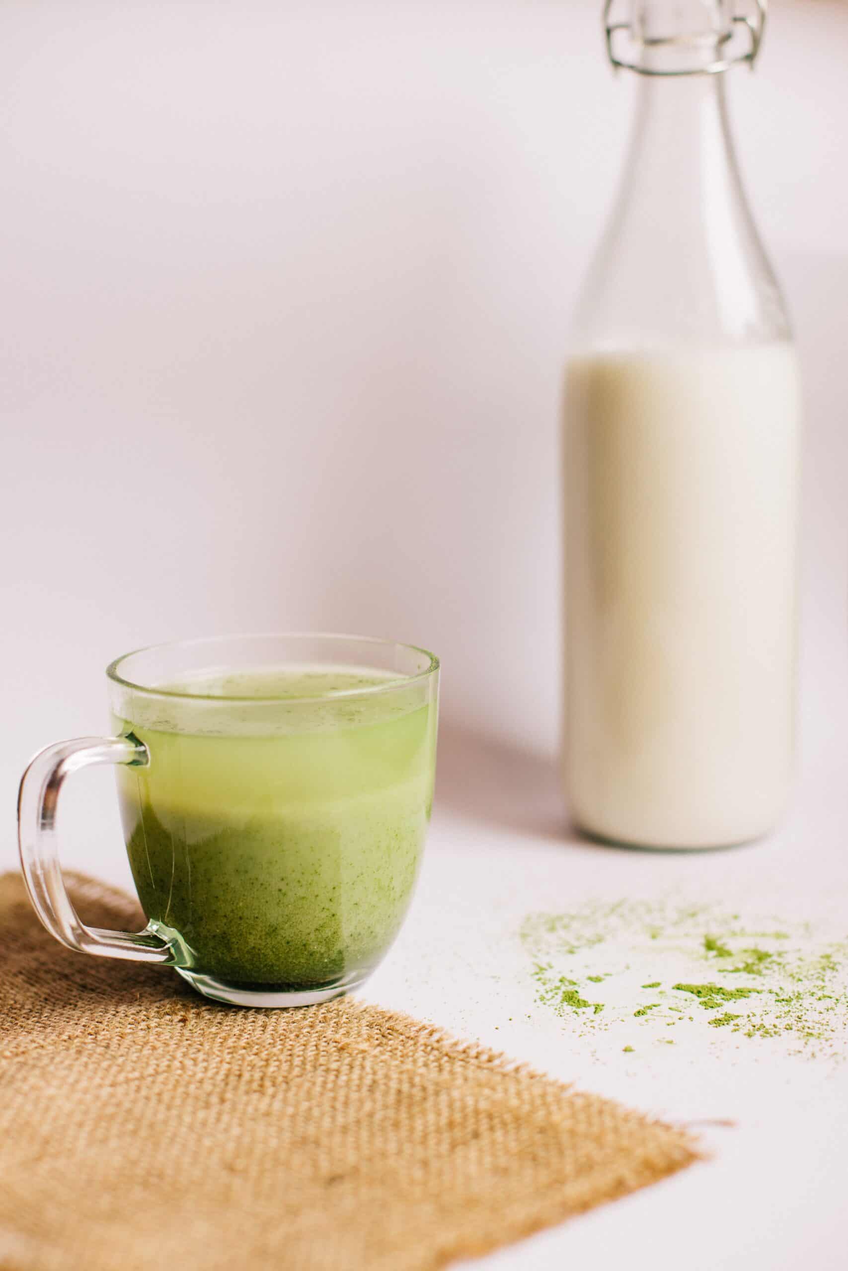 a bottle of milk and a cup of matcha tea