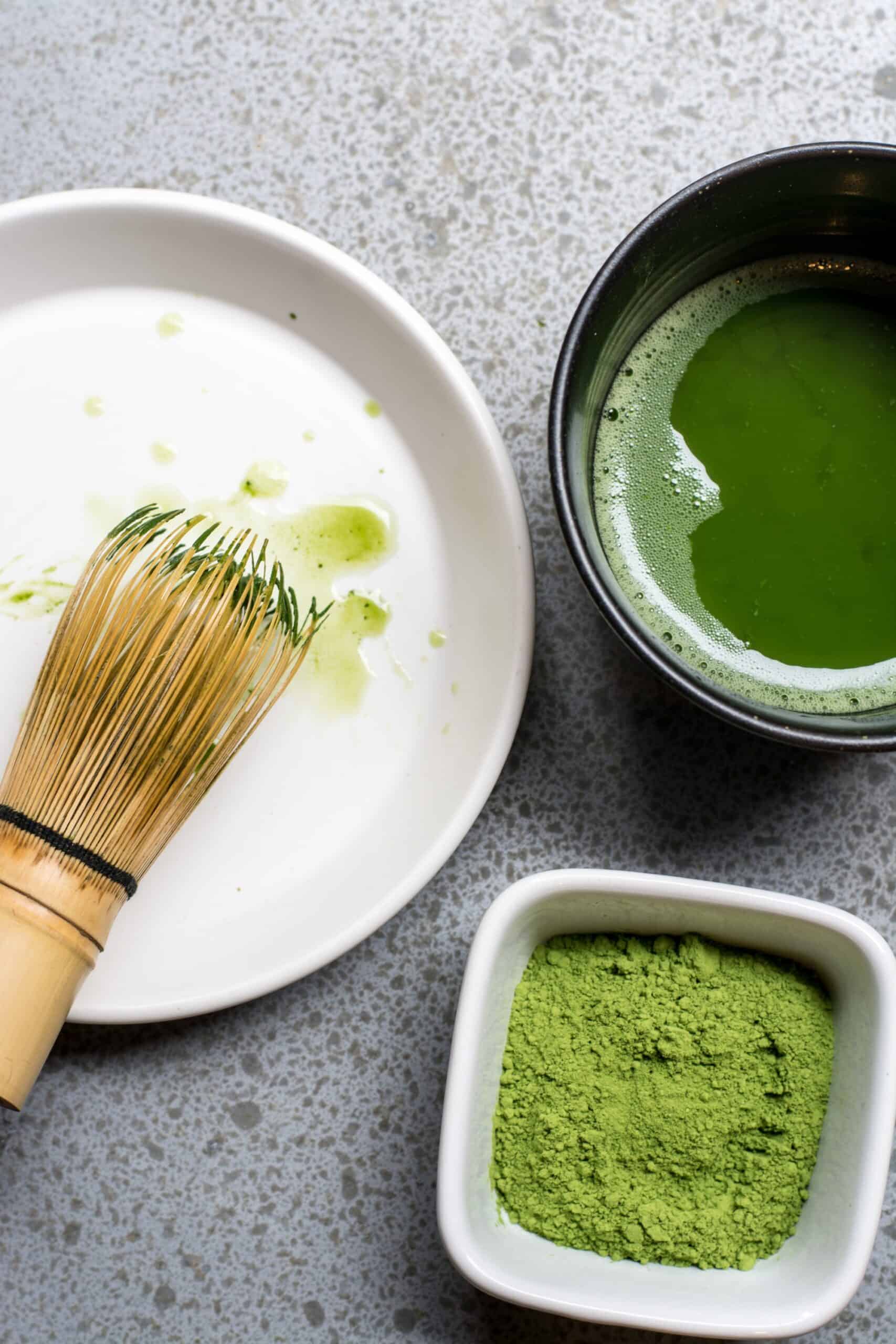 a bowl of milk, matcha tea, and matcha powder