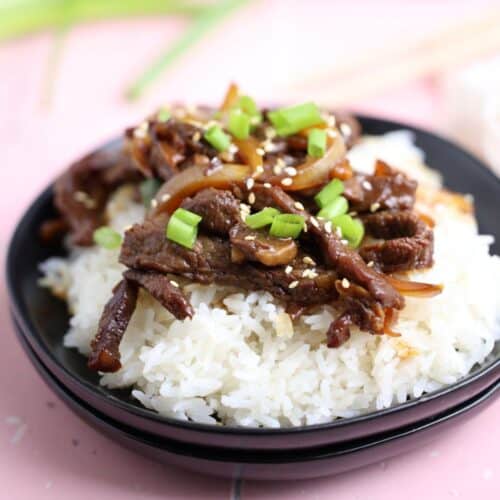 beef and onion stir fry served over a bed of vermicelli rice